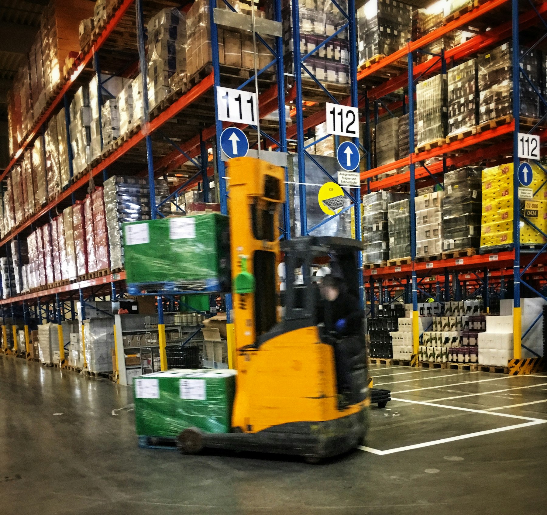 Reach truck moving a wrapped pallet through the racking of a distribution centre